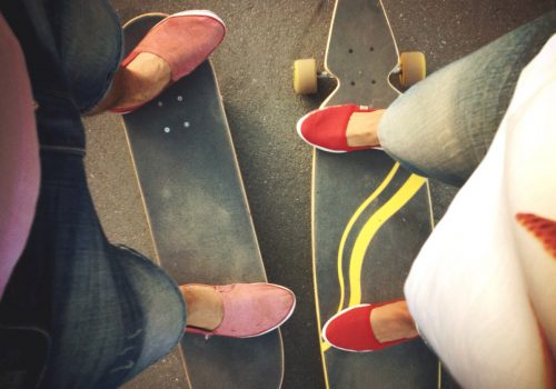 a boy's and girl's legs on boards